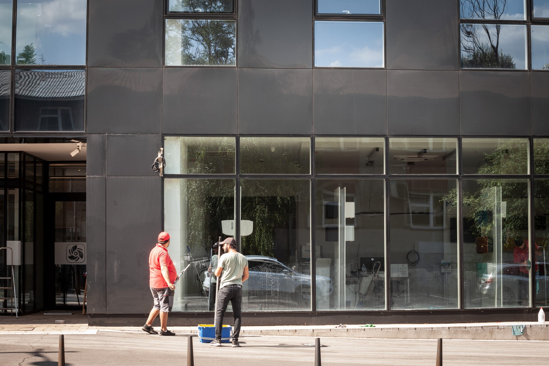 Two men, workers, window cleaners, working on an office building to wash glass and windows in belgrade.